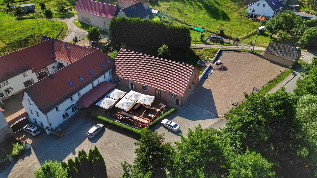 Luftaufnahme aus anderer Richtung mit Blick auf Dach, Terrasse und die Felder ringsum
