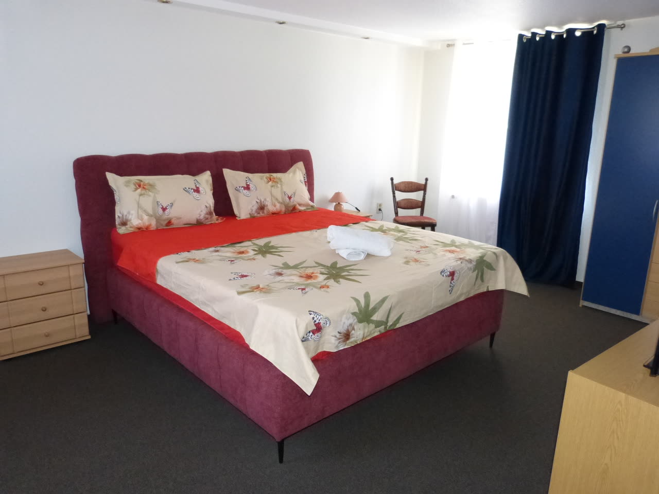 Doppelzimmer der Pension mit breitem Polsterbett, Kommode und Kleiderschrank